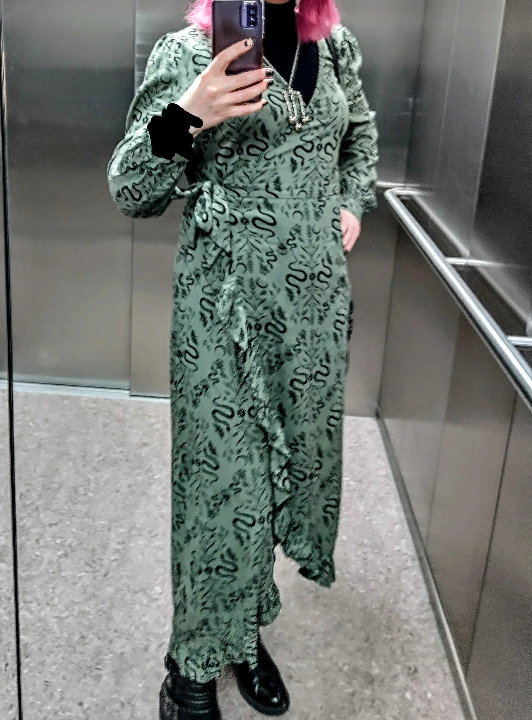 woman taking a selfie in an elevator mirror while wearing the outfit described in the text body