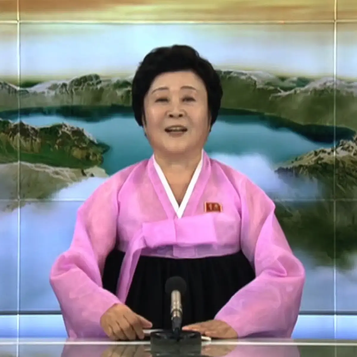 Image of a famous north Korean news presenter. Looking into the camera at her news desk