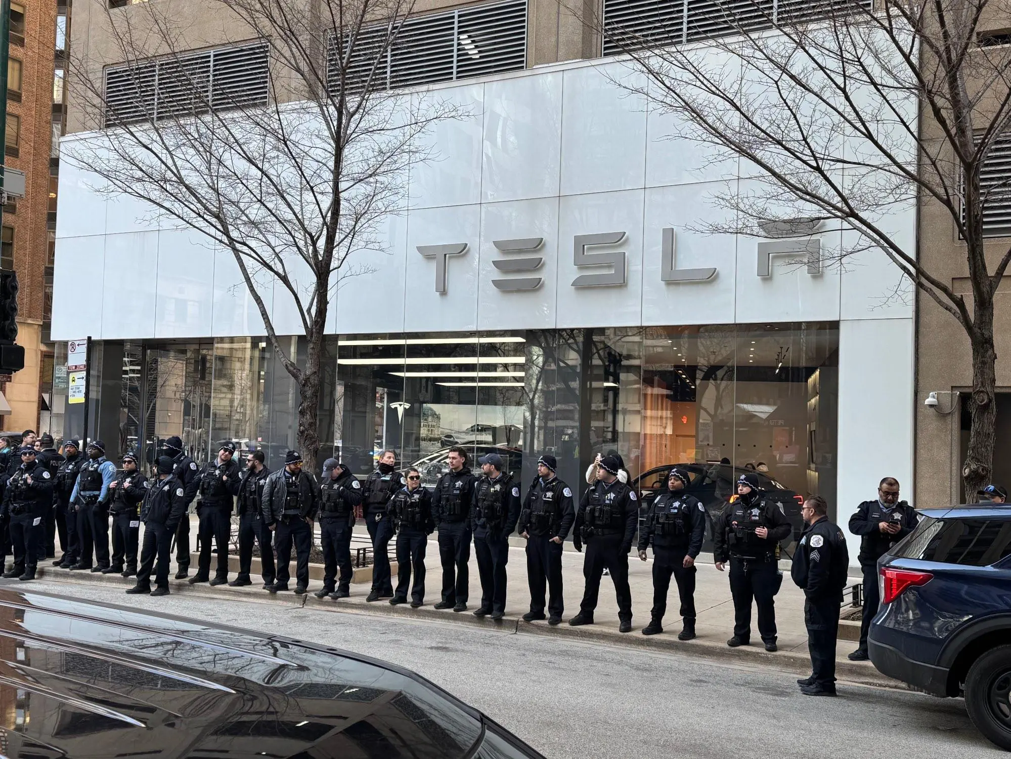 Police in front of a Tesla reseller