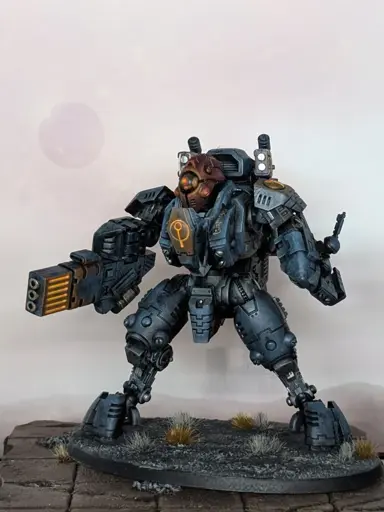 A photograph of a painted Warhammer 40,000 miniature. A Tau Ghostkeel suit in a shadowy color scheme.