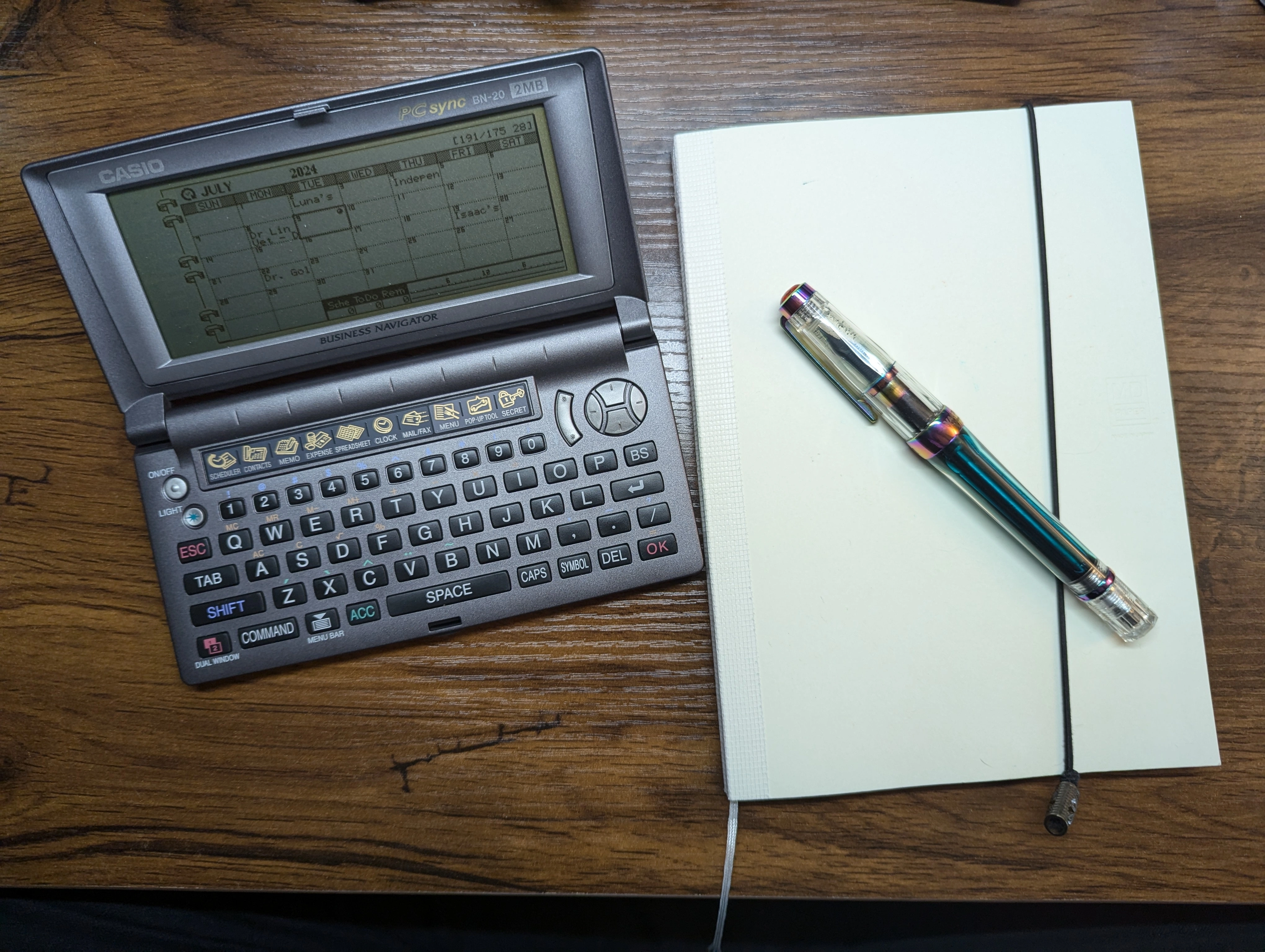 Casio BN-20 Electronic Organizer next to a Midori MD A5 size noetbook with a TWSBI Vac 700R resting on top of it